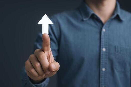 Concept of Growth and Direction A Man Pointing Towards an Upward Arrow Symbolizing Progress photo