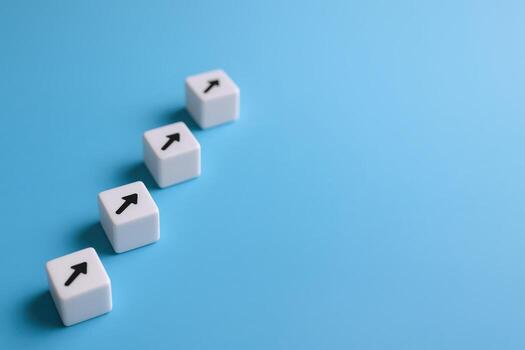 cuatro blanco cubitos con flechas ascendente diagonalmente en un azul antecedentes representando crecimiento y Progreso foto