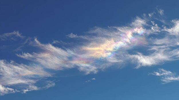 Iridescent Cloud Displaying Rainbow Colors Against Blue Sky Backdrop - Atmospheric Optical Phenomenon Meteorology photo