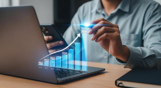 negocio crecimiento proyección desplegado con hacia arriba grafico en ordenador portátil pantalla, hombre analizando datos en móvil teléfono foto