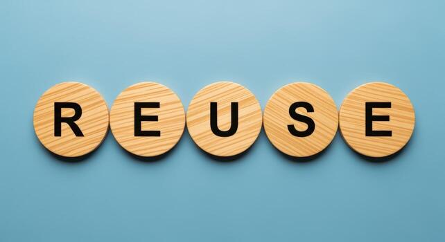 Concept of Reuse, with Wooden Round Pieces Showing the Word Reuse Against Blue Background photo