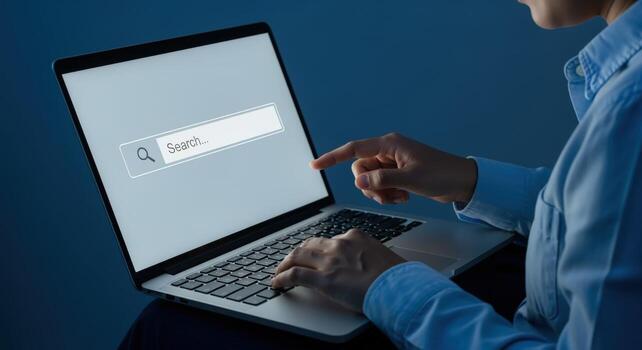 Woman using laptop search bar for online navigation, information seeking, and digital task completion photo