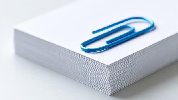 Stack of Blank White Paper with Blue Paperclip for Office Stationery and Organization photo