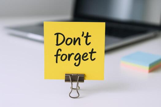 Reminder Note on Desk with Laptop in Background Urging Proactive Memory photo