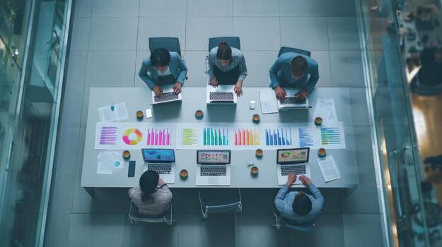Overhead View of Business Team Analyzing Charts and Data at Long Conference Table photo