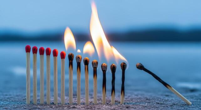Burning Matches with a Blue Background Showcasing Fires Spread and Progression in a Striking Composition photo