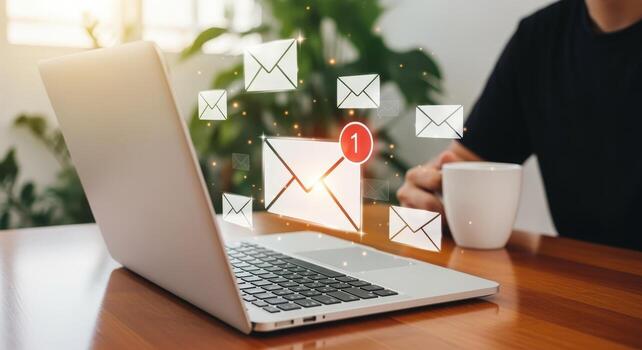 Conceptual Shot of Email Notifications Popping Up Around an Open Laptop on a Wooden Table photo