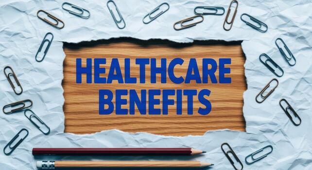 Healthcare Benefits Message Displayed on Wood Texture with Paper Clips and Pencils in a Business Setting photo