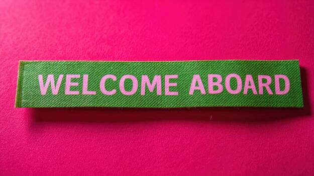Welcome Aboard Sign on a Pink Background Positive Onboarding Message for New Hires and Employees photo