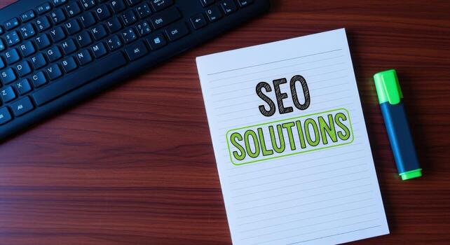 SEO Solutions Concept Keyboard, Notepad and Marker on a Wooden Table for Digital Marketing photo