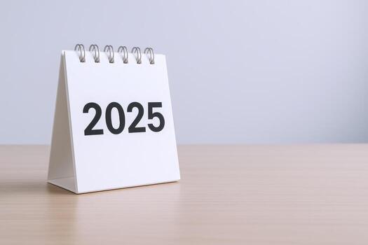 Desktop Calendar Showing 2025 Year on Wood Table, Symbolizing New Year, Future Planning and Organization photo