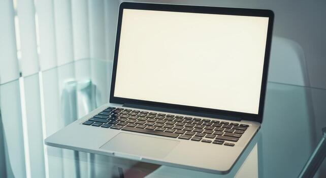 Laptop with Blank Screen on Glass Table for Mockup and Presentation Purposes in Office photo