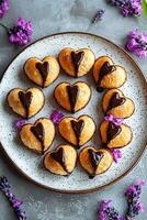 dulce corazón conformado pasteles rociado con chocolate y adornado con lavanda. foto