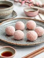Sweet Pink Mochi Delights with Tea and Cherry Blossoms Setting. photo