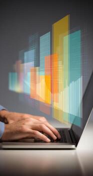 A person typing on a laptop with a colorful graphic on the screen photo