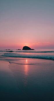 A sunset on a beach with a small island in the distance photo