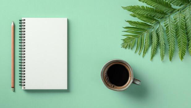 Notebook, coffee and fern leaf on green background top view photo