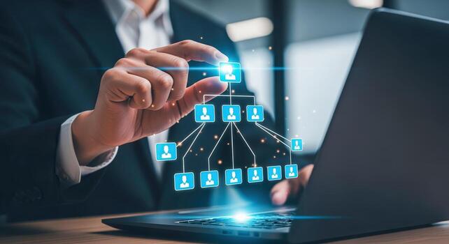 Businessperson manipulating digital hierarchy chart on laptop screen, symbolizing corporate structure and modern technology integration photo