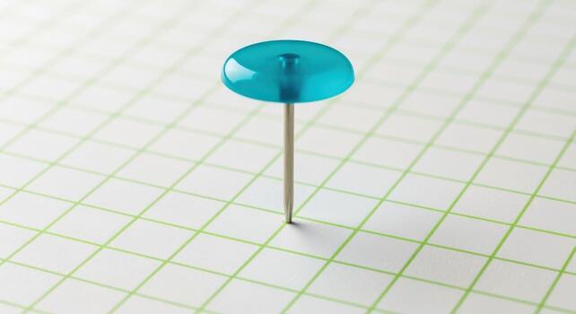 Turquoise push pin on graph paper highlighting precision and focus in planning and organization photo