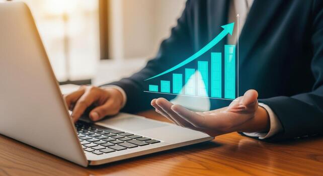 Business Growth Concept Man Holding Holographic Graph with Rising Arrow While Working on Laptop photo