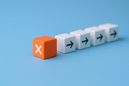 Disruption Concept Orange Block with X Stands Out from Arrow Direction Blocks on Blue Background photo