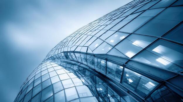 Modern architecture featuring a curved glass facade, reflecting sky and light, emphasizing design and innovation in urban development photo