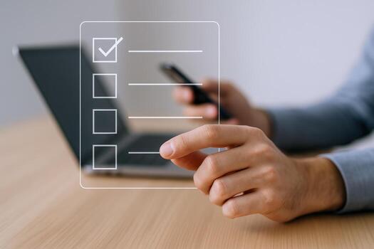 Digital Checklist Overlay with Laptop, Businessman Reviews Tasks on Mobile Phone, Task Management Concept photo