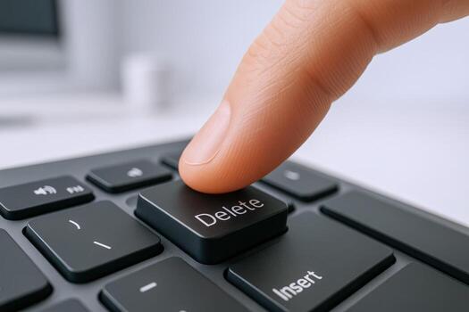 Finger Pressing Delete Key on Black Keyboard Showing Concept of Removal and Data Deletion photo