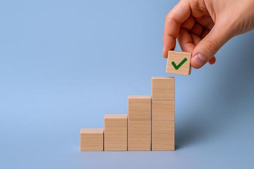 Completion of Growth Steps Hand Placing Wooden Block with Checkmark Symbol on Rising Staircase photo