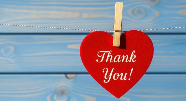 Thank You Message on Red Heart Hanging from Clothesline with Blue Wood Background photo