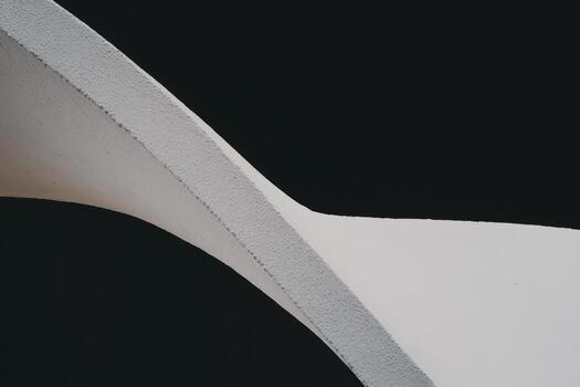 Curves of modern architecture in a minimalist design against dark background photo