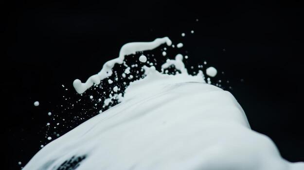 Splashing white liquid creates dynamic patterns against black background photo