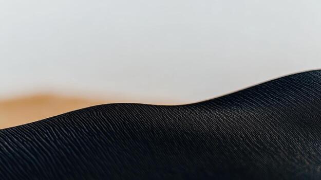 de cerca de texturizado negro material con suave curvas en contra un ligero antecedentes foto