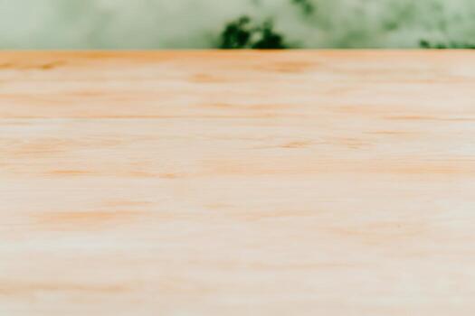 Wooden table surface with a natural backdrop in a bright setting photo