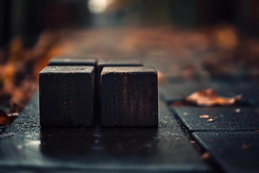 Weathered wooden blocks placed on a wet pavement during autumn evening photo