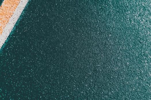 Textured asphalt surface with white and orange lines under natural light photo