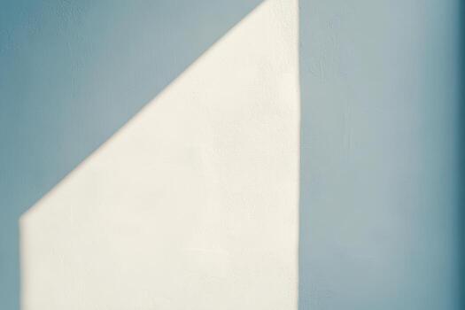 Light and shadow create a geometric pattern on a textured wall photo