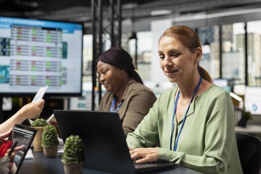 Ambitious focused businesswoman at desk reviewing business strategy after collecting reports data and performance indicators, aligning development goals driven by success. Report writing. photo