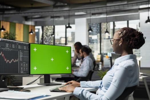 Trader in prop firm office using using trading app on green screen mockup PC to analyze market data and execute trades. Woman monitoring stock exchange using chroma key isolated screen computer photo