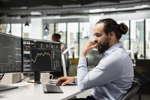 Trader at work tracking stock market trends and placing orders using trading software on PC. Financial specialist in brokerage company office trading securities on behalf of clients photo