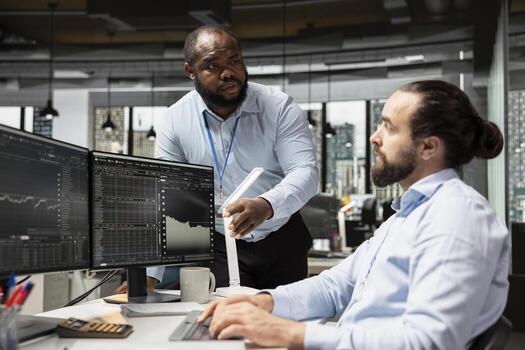 Teamworking traders in prop firm office doing brainstorming, executing trades using trading app on PC. Hedge fund coworkers and person with disability in wheelchair monitoring stock exchange data photo