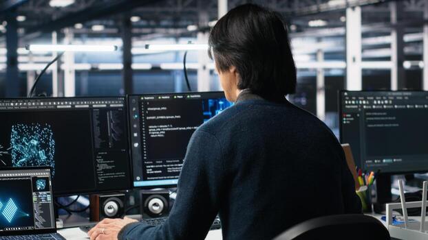 Software developer entering server room office, using AI to review infrastructure diagnostics. System administrator in data center analyzes performance data using artificial intelligence tech photo