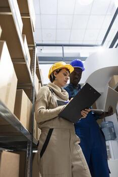 Multiethnic team of workers check shipments and inventory management within a storage room warehouse. Distribution and transportation functions are efficiently in this depot, import export. photo