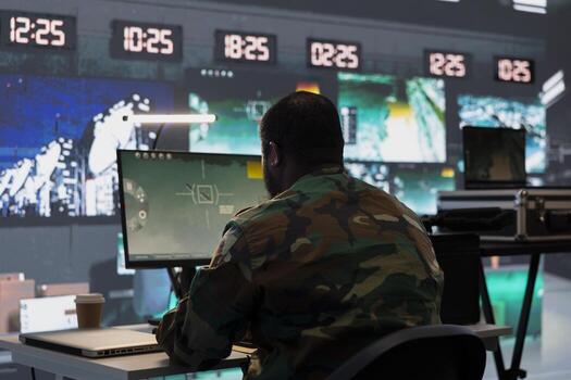 Air defense division operative using radar on computer to detect ballistic missiles. Army soldier in base of operations scanning rockets approaching national borders using PC, deploying shields photo
