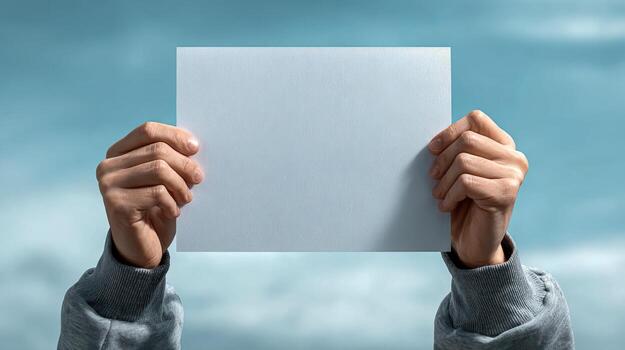 Hands Holding Blank White Card Against a Cloudy Sky Background for Advertisement or Promotion photo