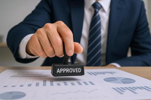 Approved Document Businessman Stamping Official Papers with Seal of Approval on Finance Report at Desk photo