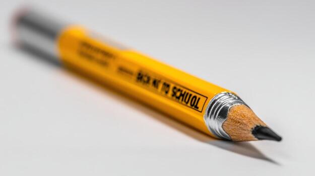 Back to School Concept Macro Shot of a Sharpened Yellow Pencil on White Background photo