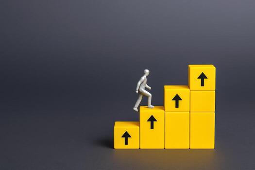 Miniature Figure Climbing Yellow Block Steps with Arrows, Illustrating Growth and Business Success photo