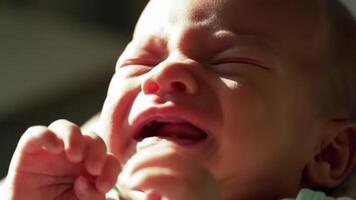 närbild av en bebis mycket liten händer och ansikte medan gråt, ljus dagsljus strömning genom en fönster video