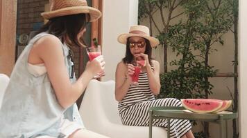 Happiness Asian family holidays, girl with casual hat and mum enjoy drinking fresh watermelon smoothies, chilling and cheerful relaxing on vacation with parent in hot summertime at outdoor terrace. video